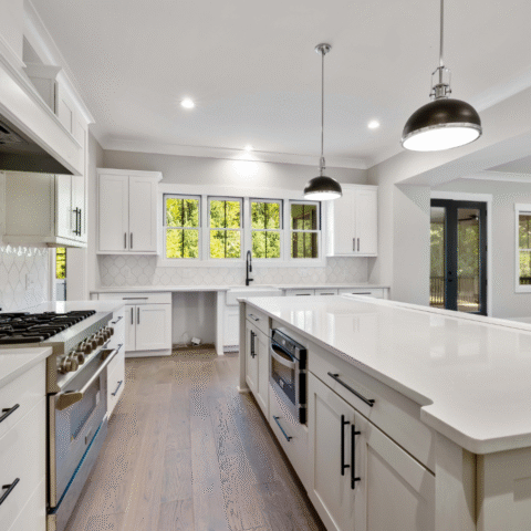 Spacious open concept white kitchen with quartz island and pendant lighting design inspiration