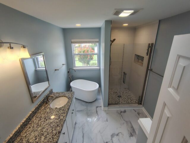 Modern bathroom remodel with glass walk-in shower and granite vanity in Chesapeake Virginia
