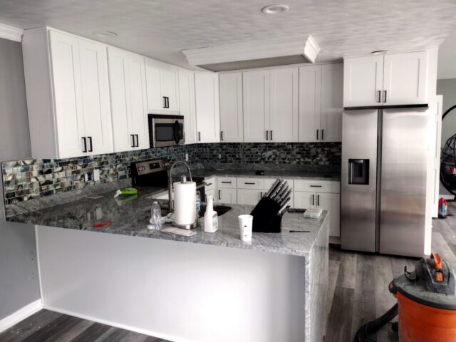 Open concept white shaker kitchen with large quartz island and stainless steel appliances in Virginia Beach VA kitchen remodel